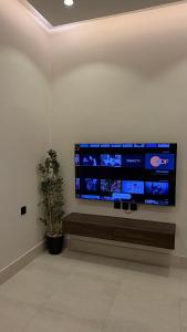 a large flat screen tv on a white wall at الربوه سويت in Jeddah