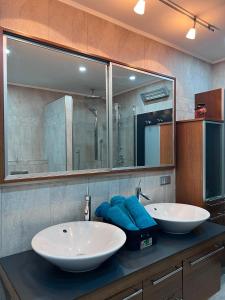 a bathroom with two sinks and a large mirror at Modernes City Apartment 8km Red Bull Ring in Knittelfeld