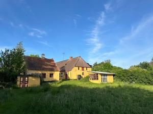 an old yellow house in a field with grass at Cozy Older Property On Ærø in Søby