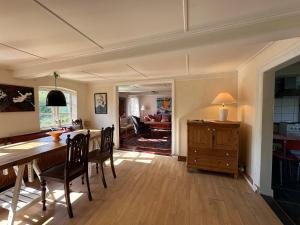 a dining room and living room with a table and chairs at Cozy Older Property On Ærø in Søby