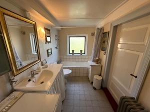 a bathroom with a sink and a toilet and a tub at Cozy Older Property On Ærø in Søby +11 photos