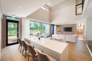 a dining room with a large white table and chairs at The Brighton Hamdeok in Jeju