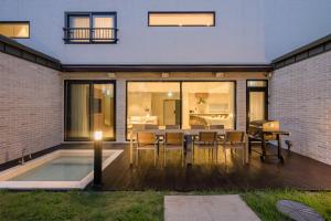 a house with a patio with a table and a pool at The Brighton Hamdeok in Jeju
