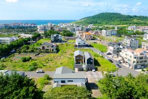 an aerial view of a small town with the ocean at The Brighton Hamdeok in Jeju