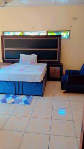 a bedroom with a bed and a couch at Quantico Guest house villa in Ndola +18 photos