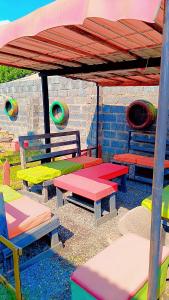a group of colorful benches sitting under a roof at Quantico Guest house villa in Ndola
