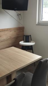a room with a table and two chairs and a television at Ferienwohnung Steger in Mattsee