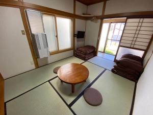 a living room with a table and a chair at Kusatsu KOTODAMA in Kusatsu