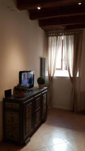 a living room with a tv on a dresser with a window at Veronetta lovely apartment in Verona