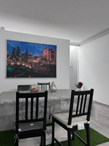 two chairs and a table in a room with a painting on the wall at Modernes City Apartment 8km Red Bull Ring in Knittelfeld