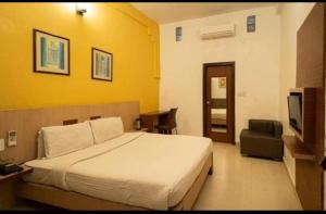 a hotel room with a bed and a television at Sparrow Hotels Alwar, Sariska in Alwar