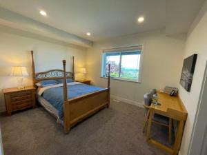a bedroom with a bed and a desk and a window at Sea view villa independent access in Nanaimo