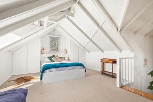 a attic bedroom with a bed and a piano at The Stables - Charming Loft with Derwent River Views in Sandy Bay