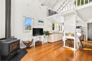 a living room with a fireplace and a stove at The Stables - Charming Loft with Derwent River Views in Sandy Bay