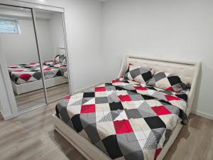 a bedroom with a bed in front of a mirror at New Haven- 2-Bedroom Suite in Winnipeg