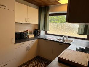 a kitchen with white cabinets and a sink and a window at Apartment Leidenberger - Nähe Rothenburg & Ansbach - 2 Schlafzimmern in Colmberg