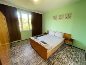 a bedroom with a bed in a room with green walls at Къща за гости САРАЯ Ретро стил in Svishtov
