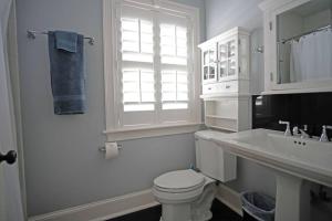 a white bathroom with a toilet and a sink at Hamilton Carriage A - Amazing Location, Courtyard in Savannah
