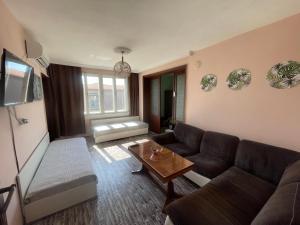 a living room with a couch and a table at Къща за гости САРАЯ Ретро стил in Svishtov