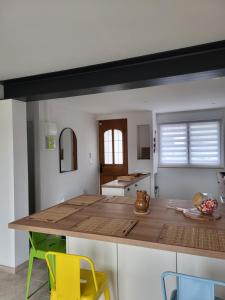 a kitchen with a wooden counter and yellow chairs at Les Oyats in Équihen-Plage
