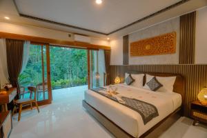 a bedroom with a large bed and a balcony at Arcana Ubud in Ubud +47 photos