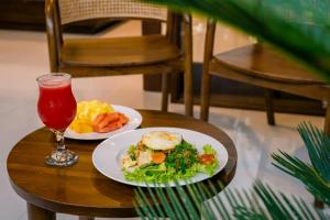 a table with two plates of food and a drink at Arcana Ubud in Ubud
