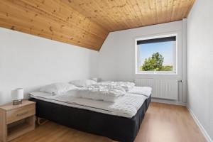 a bedroom with a bed with a wooden ceiling at Spacious Holiday Home With Water View in Redsted