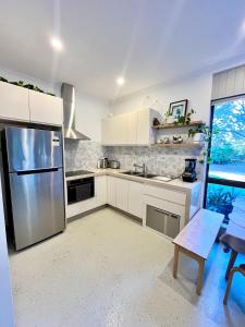 a kitchen with white cabinets and a stainless steel refrigerator at Mountain View Blue Mountains in Kurrajong