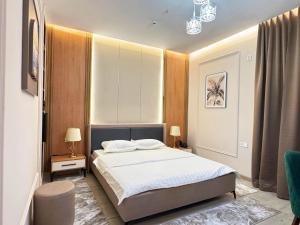 a bedroom with a bed and two tables and two lamps at Leore Hotel in Namangan +63 photos