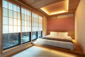 a bedroom with a bed and a large window at MR T Kamogawa East 12 in Kyoto