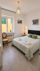 a bedroom with a large bed and a chair at Casa Giusto Ischia 3 in Ischia Town