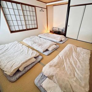 three beds sitting in a room with windows at Makeit 1to3 - Vacation STAY 17356 in Chichibu