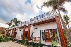 a house with palm trees in front of it at The Siantar Luxury Villa And Spa in Nusa Penida