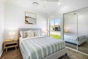 a bedroom with a king sized bed and a window at Kinma Valley Retreat KVR in Morayfield