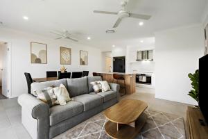 a living room with a couch and a table at Kinma Valley Retreat KVR in Morayfield