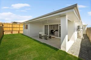 a backyard of a house with a lawn at Kinma Valley Retreat KVR in Morayfield