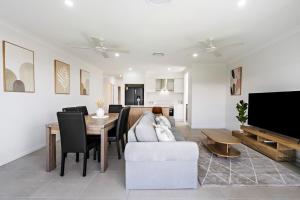 a living room with a couch and a table at Kinma Valley Retreat KVR in Morayfield