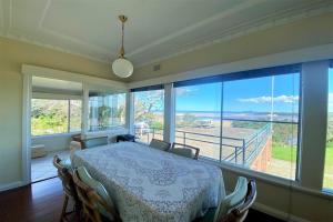a dining room with a table and a large window at 13 High Street in Nambucca Heads