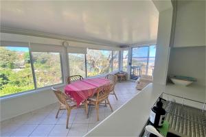 a dining room with a table and chairs and windows at 13 High Street in Nambucca Heads