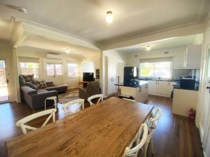 a kitchen and living room with a wooden table and chairs at 10 Clarke in Nambucca