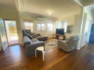 a living room with a couch and chairs and a tv at 10 Clarke in Nambucca