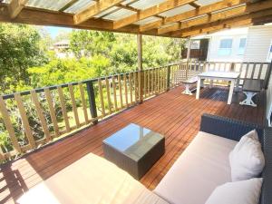 a patio with a couch and a table on a deck at 10 Clarke in Nambucca