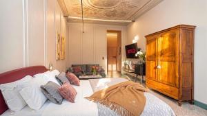 a bedroom with a large bed with a wooden cabinet at Homeby, Cinisca Suite Rose in Bologna