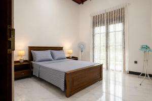 a bedroom with a bed and a large window at Ivy Garden Retreat in Gampola