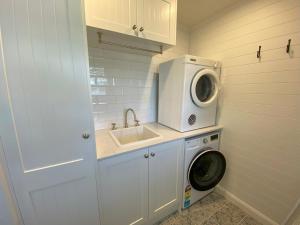 a small kitchen with a sink and a washing machine at 19 Newry St in Nambucca Heads