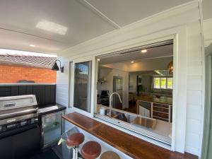 a kitchen with a sink and a large mirror at 19 Newry St in Nambucca Heads +10 photos