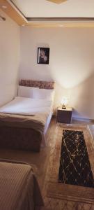 a bedroom with two beds and a table with a lamp at Pyramids Aladdin Power in Cairo