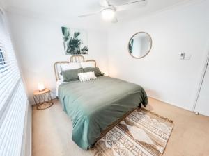 a bedroom with a bed and a mirror on the wall at 59 Short in Nambucca Heads