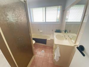 a bathroom with a shower and a sink and a tub at 59 Short in Nambucca Heads +10 photos