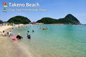 a group of people playing in the water at the beach at Yoshiharu in Toyooka